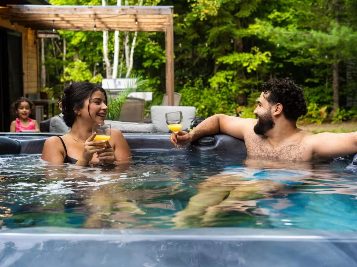 Famille au spa extérieur d’un chalet Astra